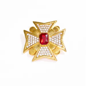 Spilla a croce vintage dorata con pietra rossa e cristalli chiari brillanti incastonati.