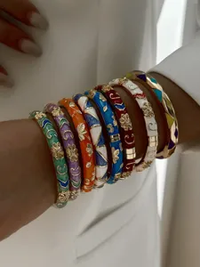 Detailaufnahme von böhmischen Emaille-Armreifen in Regenbogenfarben mit Goldakzenten