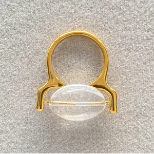 Gedetailleerde opname van een vergulde messing ring met een helder ovaal glaselement.