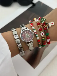 Primo piano di orologio a tema natalizio e set di braccialetti con ciondoli festivi