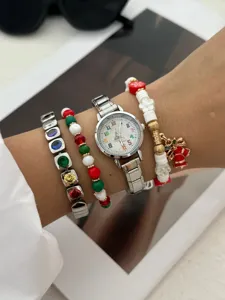 Dettaglio ravvicinato di orologio e set di gioielli natalizi con strass colorati festivi