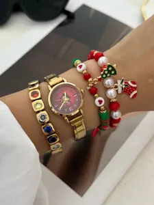 Vista dettagliata di un set orologio e braccialetto dorati a tema natalizio.