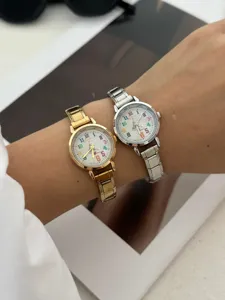 Primo piano di orologi di Natale in oro e argento con numeri colorati