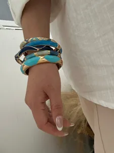 Gros plan sur des bracelets vintage en émail avec motifs d'huile colorés et dorure
