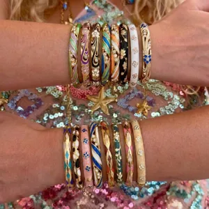 Detailansicht stapelbarer Vintage-Emaille-Armreifen mit bunten Blumenmustern am Arm