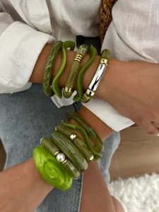 Detailopname van een groene hars armbandenset met bamboe en geometrische ontwerpen