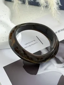 Nahaufnahme eines quadratischen Acryl-Armreifs mit dunkelbernsteinfarbener Textur.