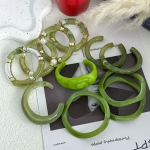 Macro-overzicht van een groene hars armbandset met goudkleurige metalen accenten.