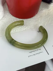 Macro-weergave van een groene gemarmerde hars armband met bamboe-gewricht design
