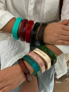 Detailweergave van meerdere kleurrijke gemarmerde acryl armbanden met een gladde afwerking