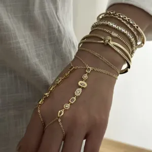 Elegante cadena de mano dorada de dedo a muñeca y pulseras de gemas apiladas detalle