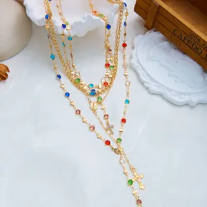 Vue détaillée du collier en Y multicouche avec strass colorés et pendentif de croix