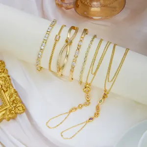 Detalle de conjunto de joyas doradas con pulseras de cristal y cadenas de mano
