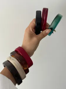 Gedetailleerd overzicht van gemarmerde acryl armbanden op de arm in verschillende kleuren