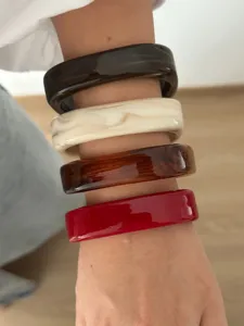 Stijlvolle set dikke acryl armbanden met gemarmerde kleuren gedragen op de arm