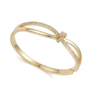 Vista detallada de un elegante brazalete dorado con diseño de nudo adornado con piedras