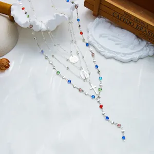 Vue détaillée du collier en Y argenté avec des strass colorés et un pendentif en croix.