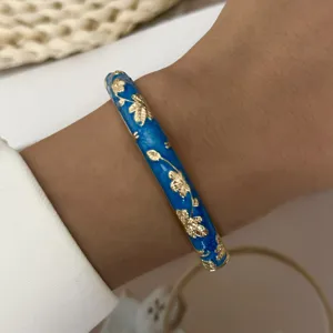 Detailed macro view of the gold leaf pattern on the blue drip oil bangle bracelet