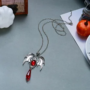 Dettaglio della collana gotica a pipistrello con pietra rossa e pendente a goccia