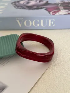Gedetailleerd macrozicht van een rode gemarmerde acryl armband met een uniek ontwerp