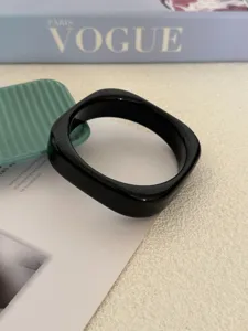 Detail van een zwarte minimalistische onregelmatige geometrische acryl armband