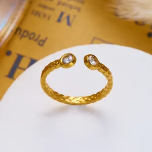 Detailansicht eines goldenen strukturierten offenen Rings mit klaren Kristallen