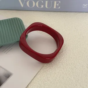Detailopname van een rode onregelmatige acryl armband op een stijlvolle achtergrond