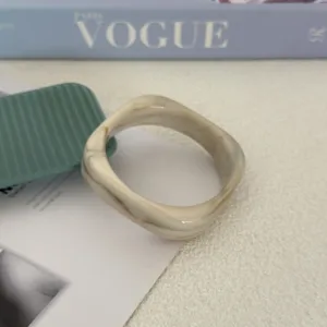 Gedetailleerde weergave van de crème gemarmerde acryl armband met minimalistisch ontwerp