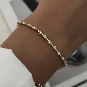Vista macro de una delicada pulsera chapada en oro con cristales transparentes brillantes