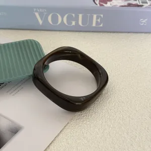 Gedetailleerd overzicht van onregelmatige bruine gemarmerde acryl armband met glans.