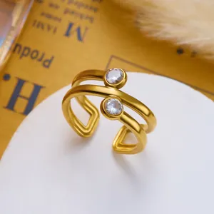 Nahaufnahme eines eleganten goldenen zweilagigen Rings mit zwei funkelnden Steinen.