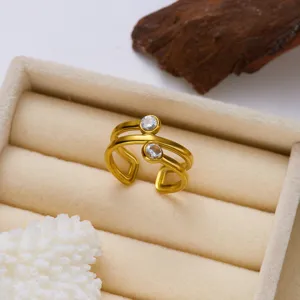 Detailaufnahme eines minimalistischen goldenen Doppelband-Wickelrings mit zwei Steinen.