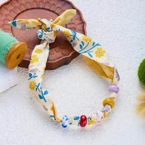 Primer plano de un accesorio de cuello de tela floral con cuentas coloridas para la playa.