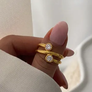 Nahaufnahme eines eleganten goldenen Doppelringes mit brillantgeschliffenen Zirkonias