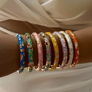Stack of colorful gold-plated enamel flower bangles with vintage ethnic designs