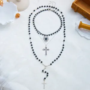 Détail montrant trois couches de collier gothique avec perles noires et croix d'argent