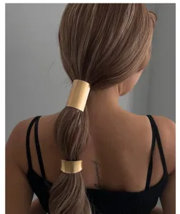Detailansicht minimalistischer goldener Haarmanschetten an einer Zopffrisur für Damen.