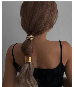 Detailansicht von goldenen Haarringen am Pferdeschwanz, minimalistischer Haarschmuck