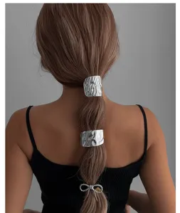Detailansicht von silbernen Haarspangen aus strukturiertem Metall für langes Haar
