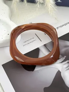 Detailansicht eines quadratischen Acryl-Armreifs mit bernsteinfarbener Marmorierung