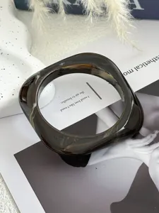 Makroansicht der Textur eines quadratischen, geometrischen Acryl-Armreifs in Marmor.
