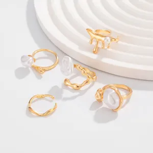 Detailansicht goldener Lavaringe mit flüssiger Textur und weißen Perlenakzenten