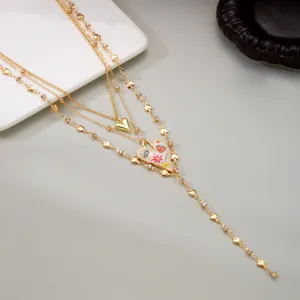 Detail of gold multi-layered necklace with hand-painted heart and heart-shaped links.