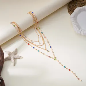 Detail of a multi-layer gold necklace with colorful rhinestones and pearls on a starfish prop