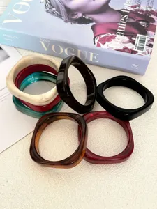 Close-up van onregelmatige gemarmerde acryl armbanden met gladde geometrische vorm.