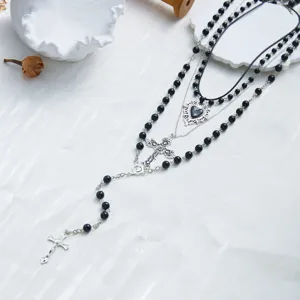 Vue macro détaillée du collier à plusieurs rangs avec perles noires, croix et cœur argent