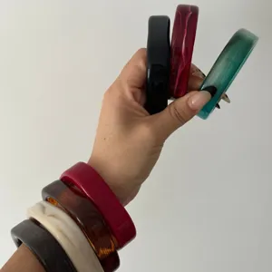 Elegante collectie onregelmatige glanzende gemarmerde acryl armbanden op een hand