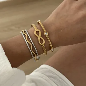 Detailansicht eines goldenen Unendlichkeitssymbols und Kristallperlen-Armband-Sets