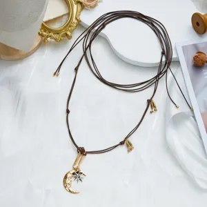 Detailed view of bohemian adjustable brown cord necklace with moon and star pendant.