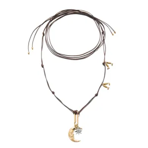 Detail view of Bohemian brown cord necklace with gold moon and silver star pendant.